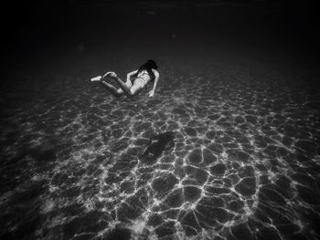 Rear view of woman swimming in sea