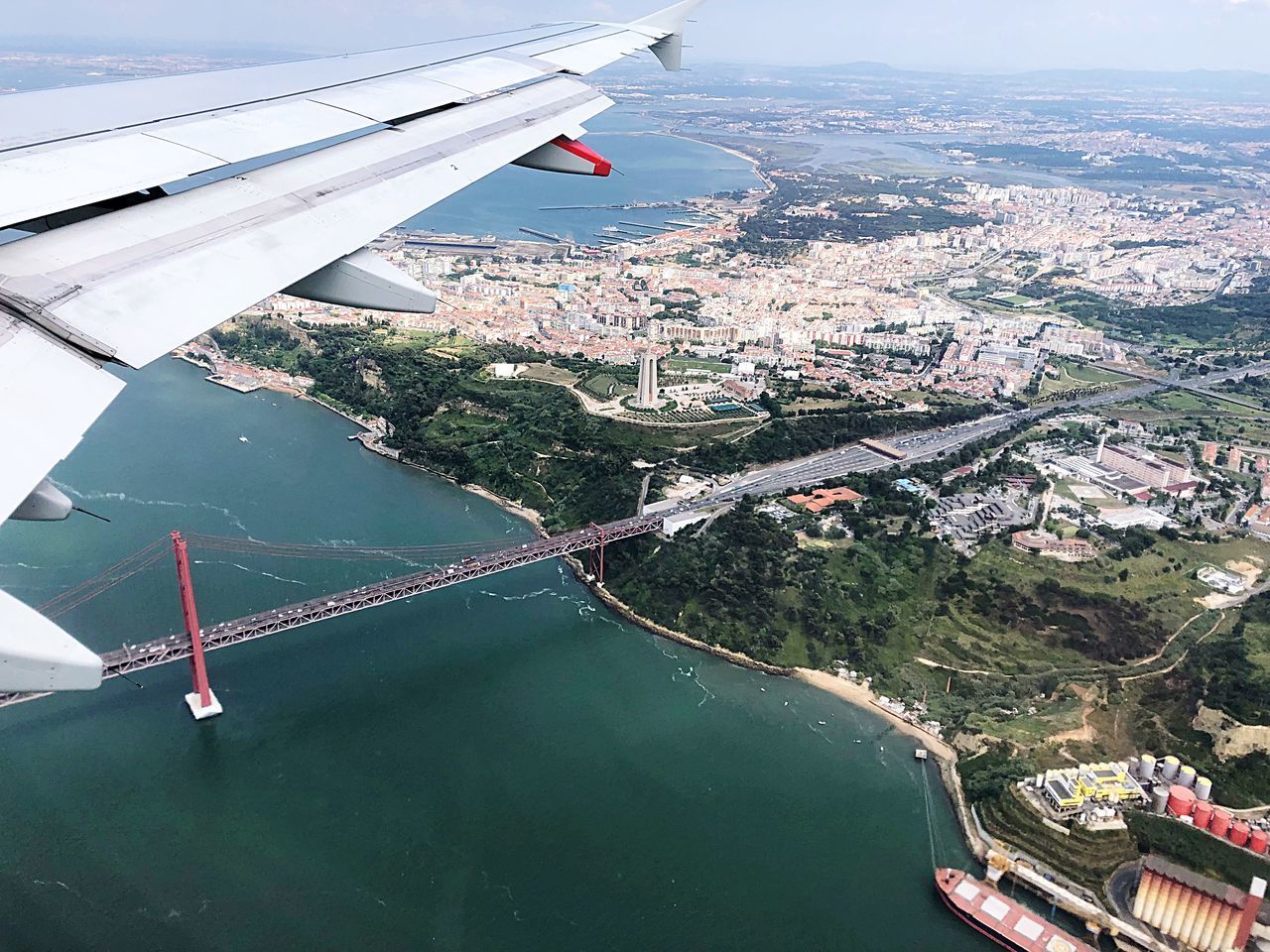 HIGH ANGLE VIEW OF CITYSCAPE AND AIRPLANE FLYING OVER CITY