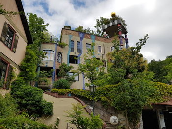 Low angle view of trees and buildings against sky