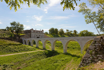 Arch bridge against cloudy sky