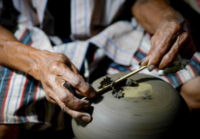 Midsection of man making pottery