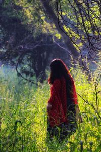 Woman standing on field in forest