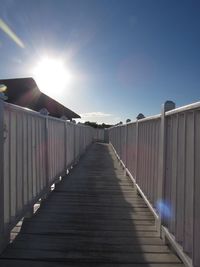 Footbridge against clear sky on sunny day