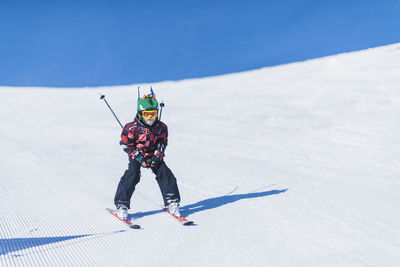 Boy skiing on snowcapped mountain