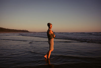 Beautiful woman on long beach at sunset in tofino