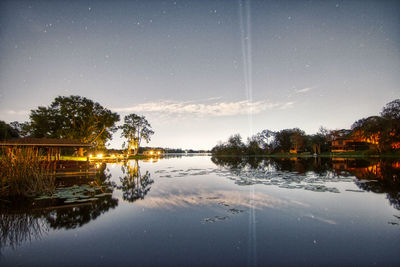 Scenic view of lake against sky at night