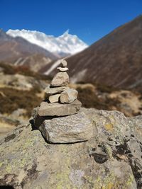 Stack of rocks on mountain against sky