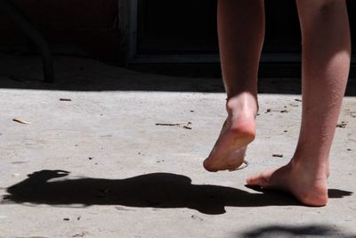 Low section of woman walking on road