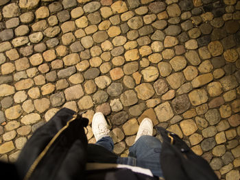 Low section of man standing on cobblestone