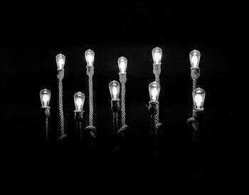 Close-up of illuminated light bulb against black background