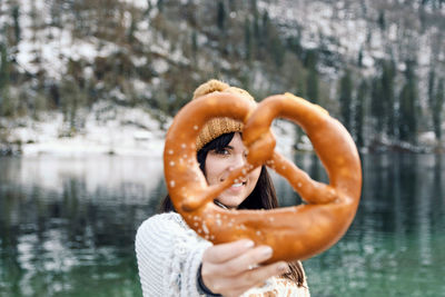 Portrait of woman holding a pretzel. selective focus, smile, winter.