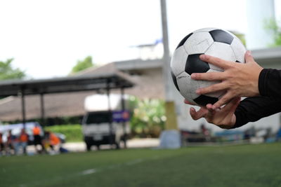 Cropped hands holding soccer ball