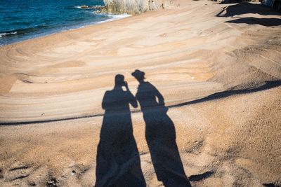 Shadow of man and woman at beach