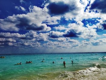 People on beach against sky