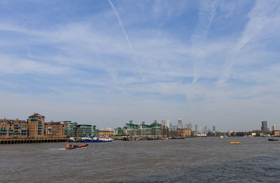 Sea by buildings against sky in city