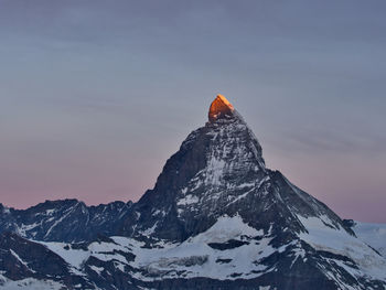 Scenic view of snowcapped mountain against sky during sunrise 