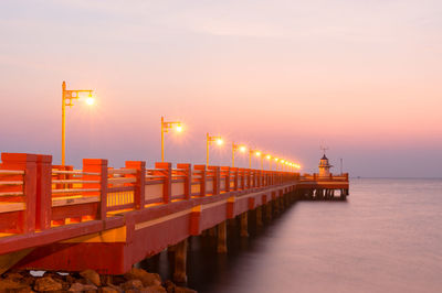 Pier over sea against sky during sunset