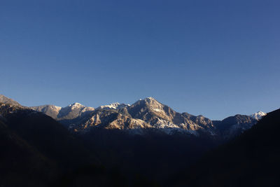 Scenic view of snowcapped mountains against clear blue sky