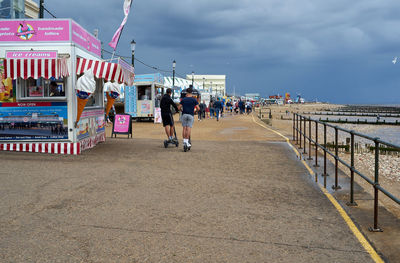 People at beach against sky