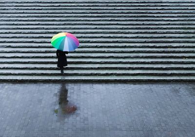 High angle view of woman walking with umbrella