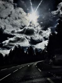 Country road against cloudy sky