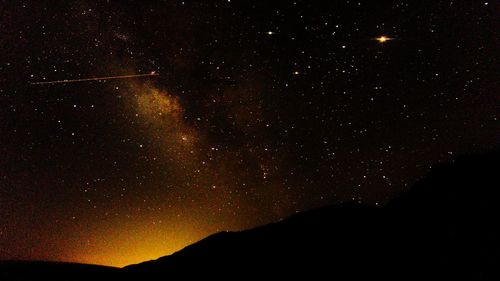 Scenic view of silhouette mountain against sky at night