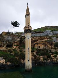 Lighthouse amidst buildings against sky