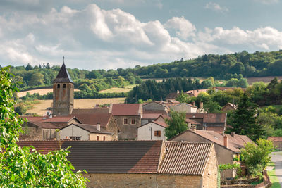 Houses and buildings in town against sky