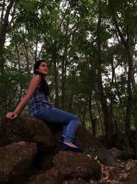 Full length of woman standing in forest