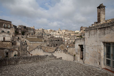 Buildings in town against cloudy sky