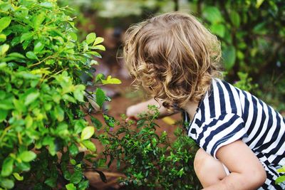 Girl crouching by plants