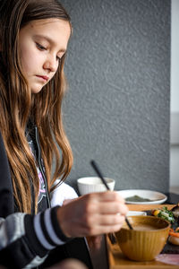 Young woman using mobile phone at home