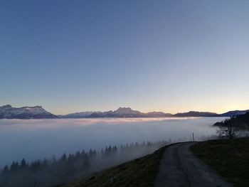 Scenic view of road against clear sky during sunset