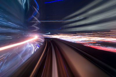 Light trails on illuminated bridge at night