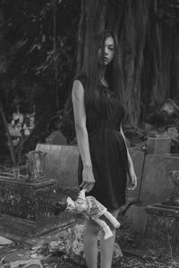 Portrait of young woman standing in forest