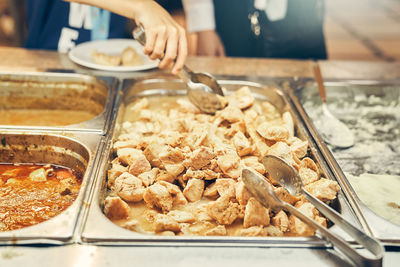 Cropped hand of man preparing food on table