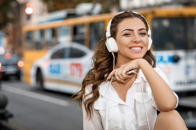 Portrait of young woman standing in city