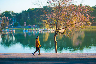 Man standing by lake against trees