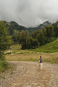 Rear view of man on mountain against sky