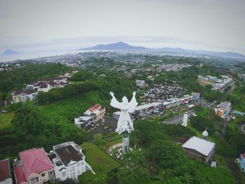 Statue amidst trees in city against sky