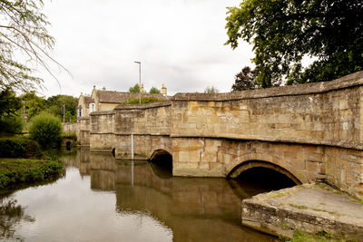 Arch bridge over river against sky