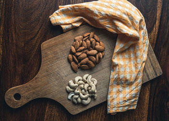 High angle view of almond and cashew on wooden table