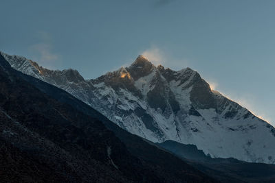 Low angle view of snowcapped mountains against sky