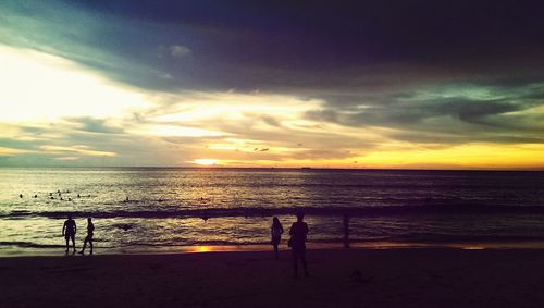 Scenic view of sea against cloudy sky during sunset