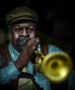 Close-up of man playing musical equipment at night