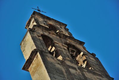 Low angle view of bell tower against blue sky