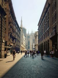 People walking on road along buildings