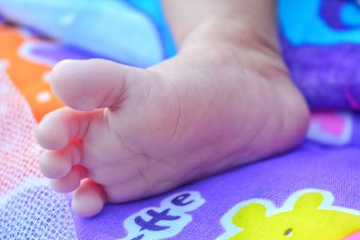 Close-up of baby hand on bed