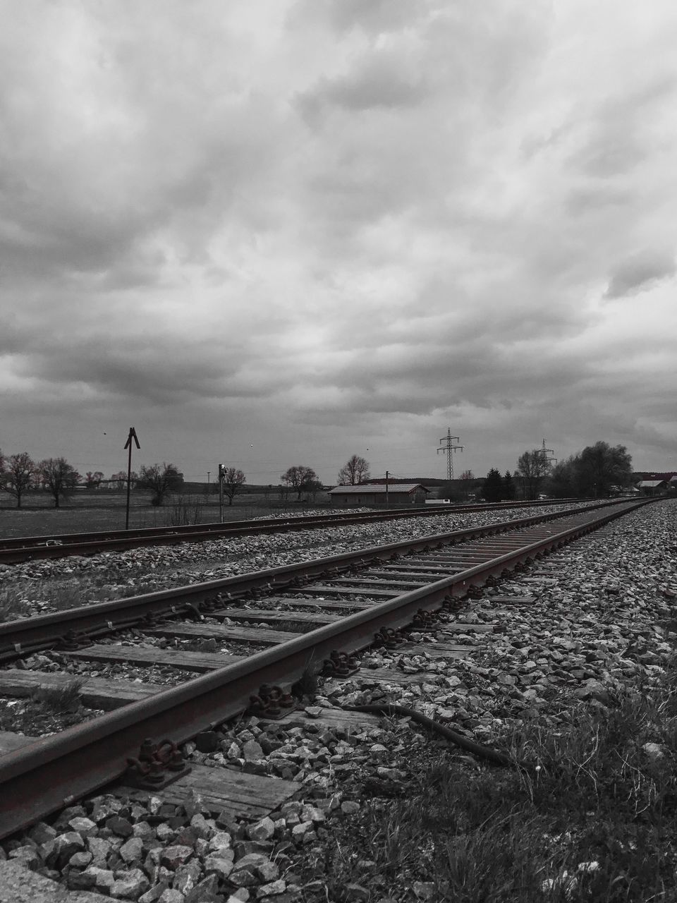 RAILROAD TRACK AGAINST CLOUDY SKY