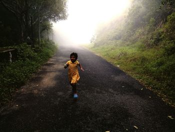 Rear view of boy on road